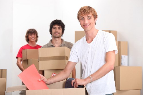 Workers loading bulky sofas and chairs for furniture pick-up